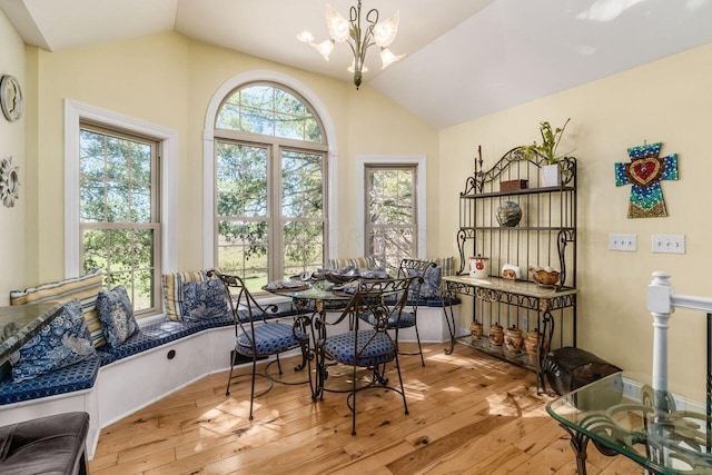 dining area featuring light hardwood / wood-style flooring, lofted ceiling, and an inviting chandelier