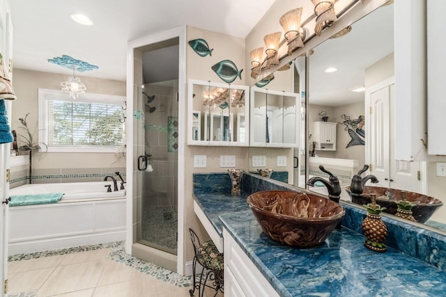 bathroom with tile patterned floors, separate shower and tub, vanity, and an inviting chandelier