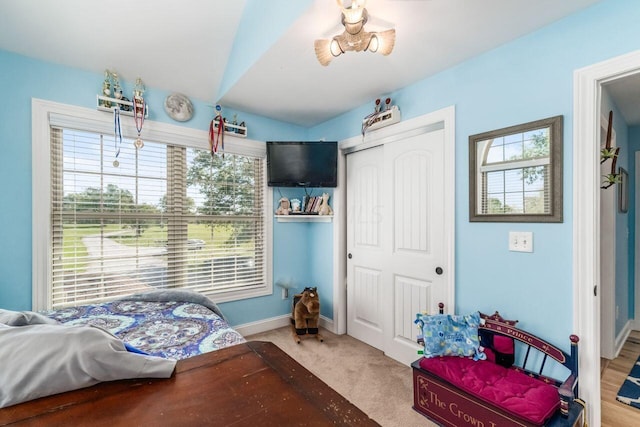 carpeted bedroom with a closet and lofted ceiling