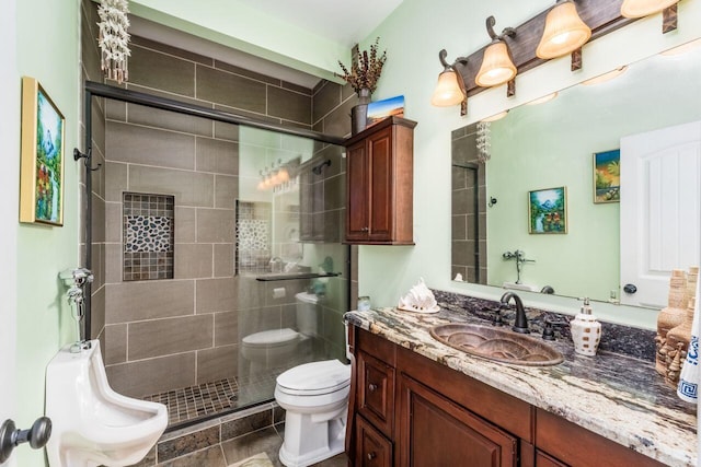 bathroom featuring tile patterned floors, vanity, a shower with shower door, and toilet