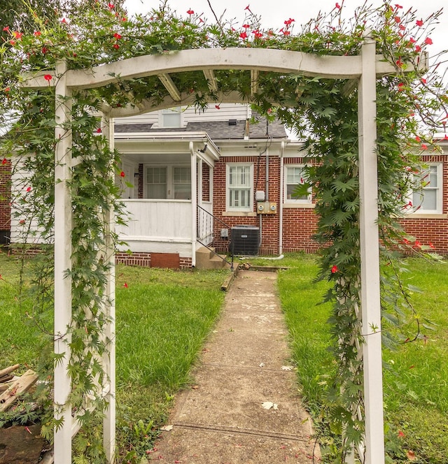 view of front of property featuring a front yard and central AC