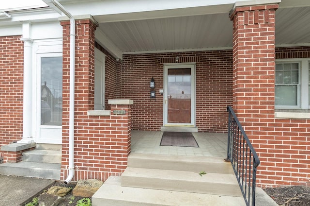 view of exterior entry featuring covered porch