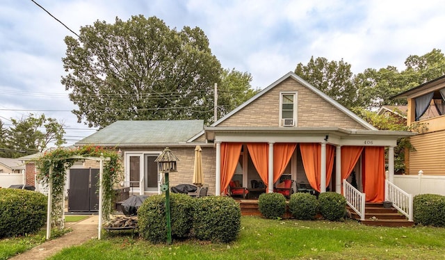 rear view of house with a porch and a yard