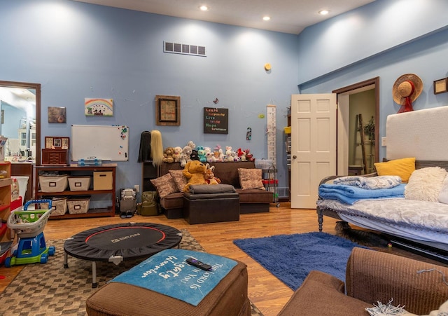 living room featuring light hardwood / wood-style flooring and a towering ceiling