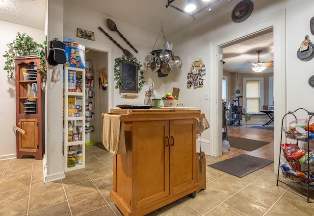 kitchen with light tile patterned floors, a textured ceiling, and ceiling fan