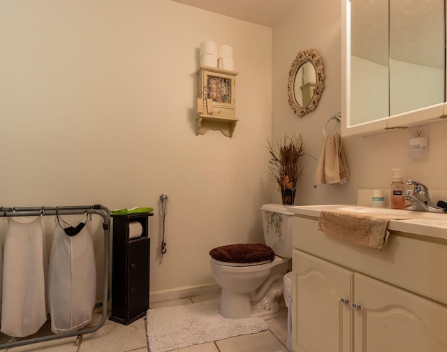 bathroom with toilet, a textured ceiling, vanity, and tile patterned floors