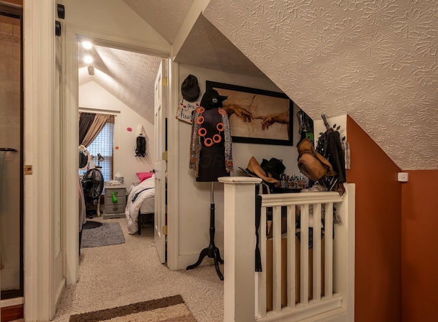 corridor featuring lofted ceiling, carpet floors, and a textured ceiling