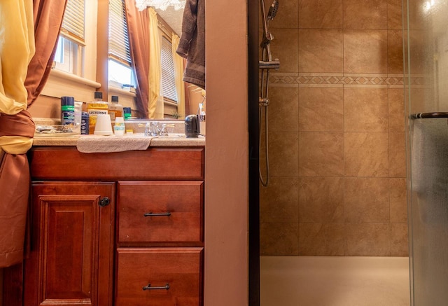 bathroom featuring tiled shower and vanity