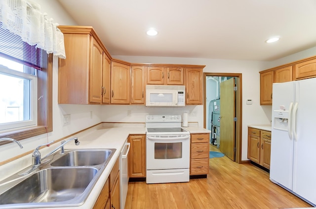 kitchen featuring light wood-type flooring, white appliances, and sink