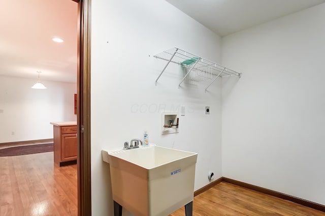 washroom with hookup for an electric dryer, light wood-type flooring, sink, and washer hookup