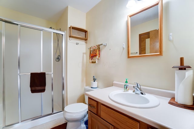 bathroom with tile patterned floors, vanity, toilet, and an enclosed shower