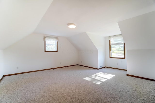 bonus room with light carpet and lofted ceiling