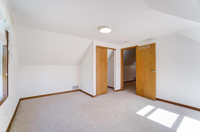 bonus room with light carpet and lofted ceiling