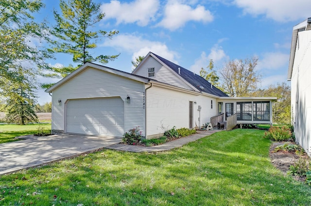 view of side of property with a sunroom, a garage, and a yard