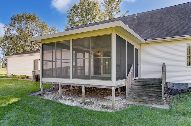 back of house with a yard and a sunroom