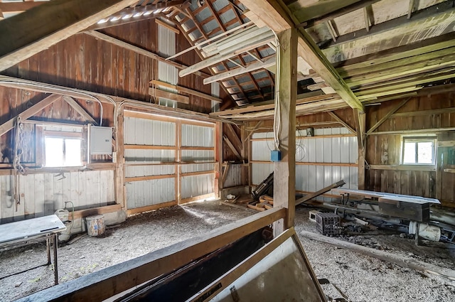 misc room with wood walls and lofted ceiling