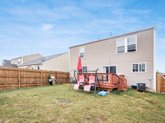 back of property with a yard, a deck, and central AC unit