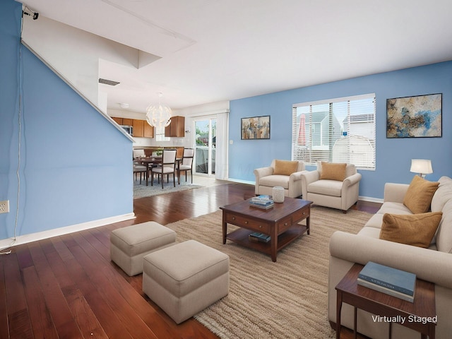 living room with hardwood / wood-style flooring and a notable chandelier