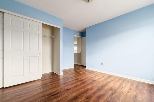 unfurnished bedroom with baseboards, a closet, and wood finished floors