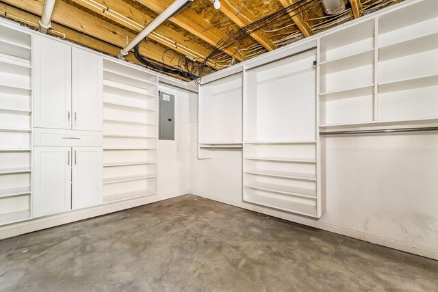 basement with baseboards and electric panel
