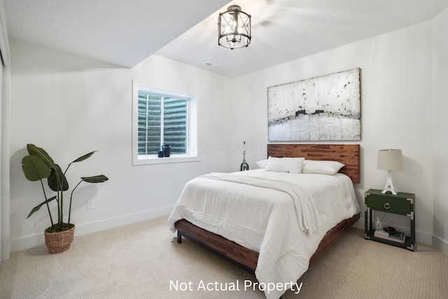 carpeted bedroom featuring an inviting chandelier