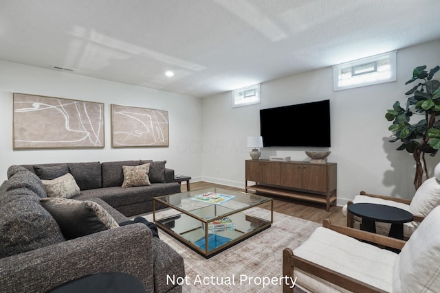 living room with wood-type flooring, a textured ceiling, and a wealth of natural light