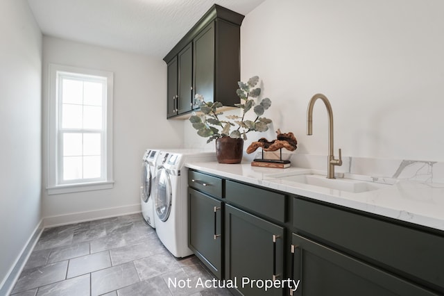 laundry room with cabinets, washing machine and dryer, and sink