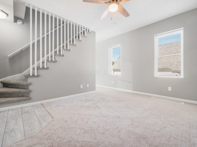 interior space with carpet flooring, a wealth of natural light, and ceiling fan