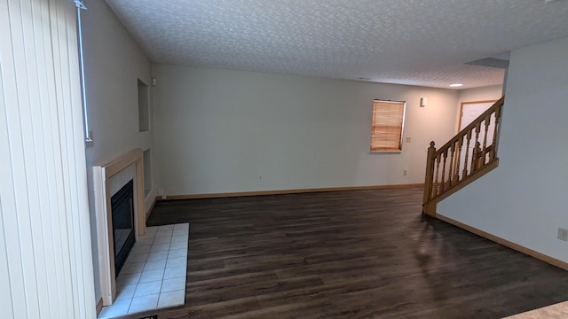 unfurnished living room featuring dark hardwood / wood-style floors and a textured ceiling