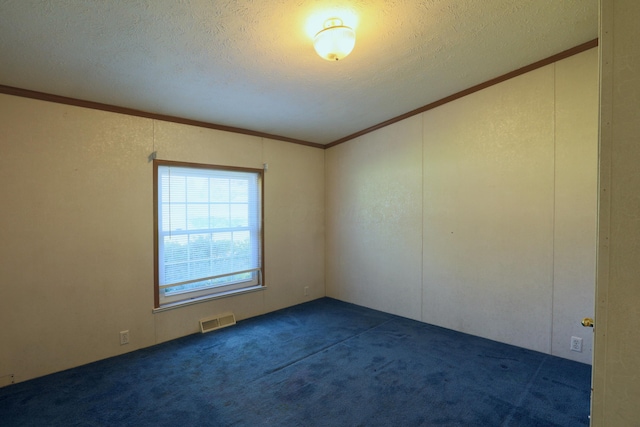 empty room featuring a textured ceiling, dark carpet, and crown molding