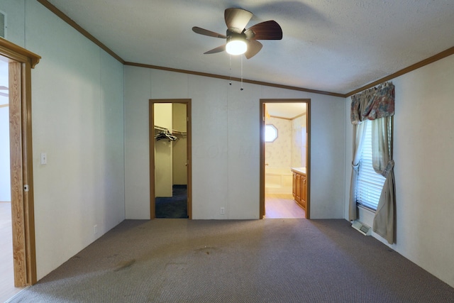 unfurnished bedroom with connected bathroom, vaulted ceiling, ceiling fan, and ornamental molding