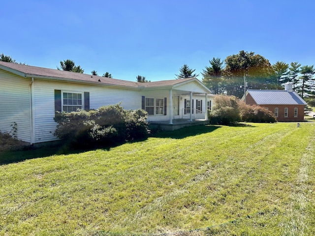 rear view of house featuring a lawn