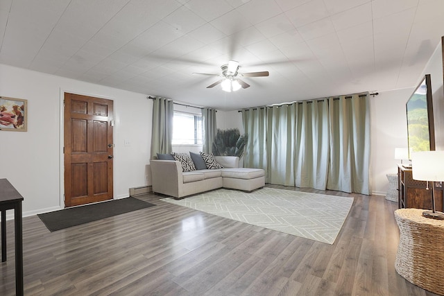 living room with a baseboard heating unit, ceiling fan, and hardwood / wood-style floors