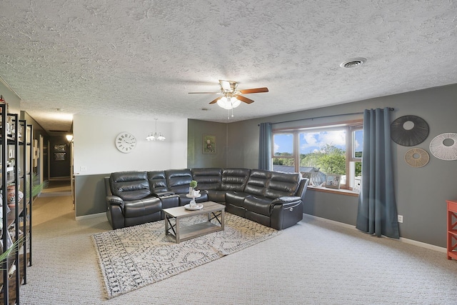 living room with a textured ceiling, carpet, and ceiling fan with notable chandelier