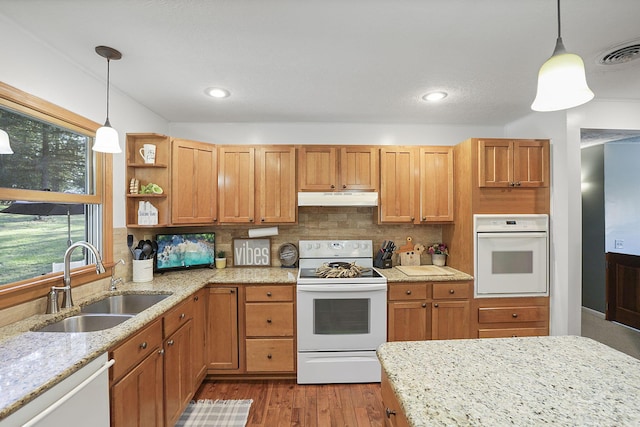 kitchen with white appliances, hanging light fixtures, backsplash, and sink