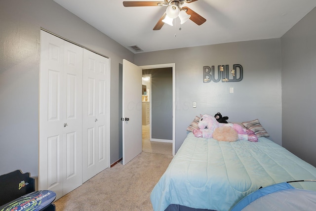 carpeted bedroom featuring ceiling fan and a closet