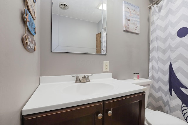 bathroom with toilet, vanity, and a shower with curtain