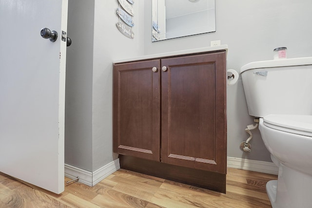 bathroom with toilet, vanity, and hardwood / wood-style flooring