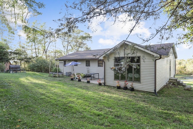 rear view of house with a yard and a patio area