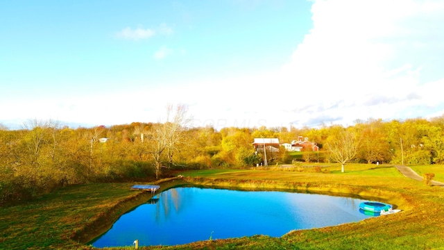 view of pool featuring a yard and a water view