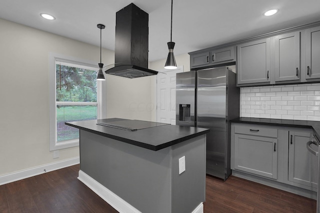 kitchen with gray cabinets, stainless steel fridge, decorative light fixtures, dark hardwood / wood-style flooring, and island exhaust hood