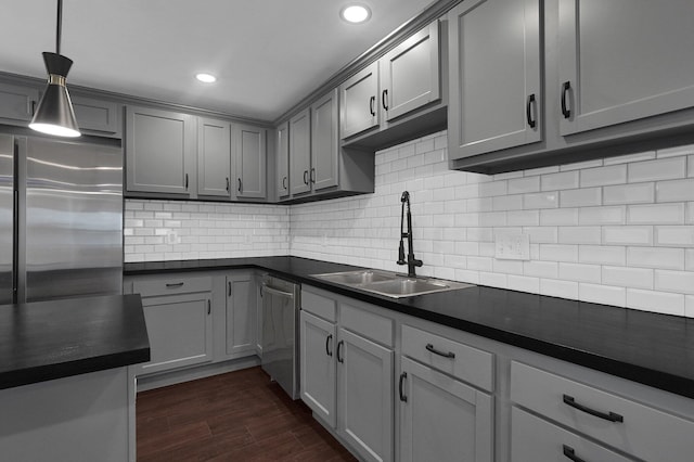 kitchen featuring appliances with stainless steel finishes, tasteful backsplash, gray cabinetry, sink, and dark hardwood / wood-style floors