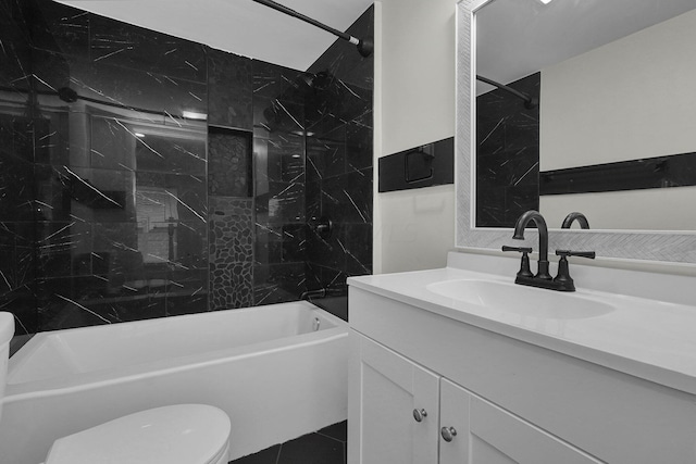 full bathroom featuring tiled shower / bath, vanity, tile patterned floors, and toilet