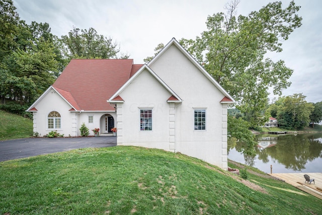 view of front of house featuring a water view and a front lawn