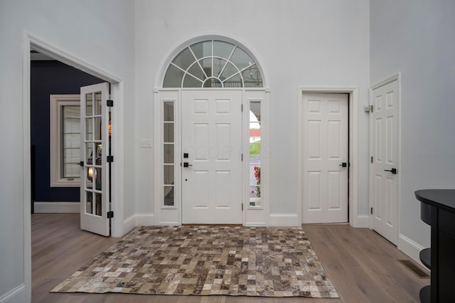 foyer entrance with a towering ceiling and hardwood / wood-style flooring