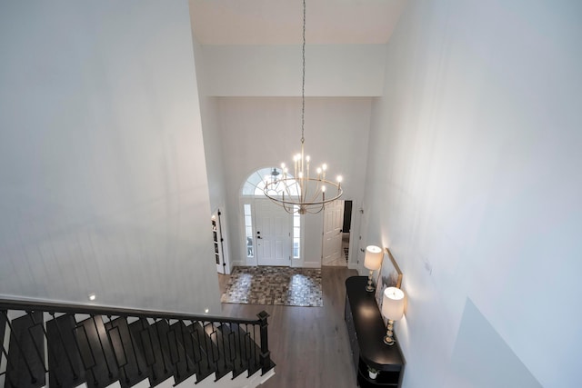 foyer entrance featuring a chandelier, hardwood / wood-style floors, and a towering ceiling