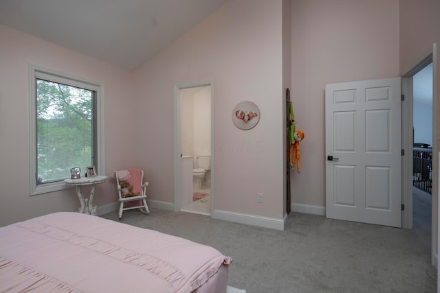 bedroom with ensuite bath, high vaulted ceiling, and light colored carpet