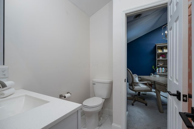 bathroom with vanity, toilet, and lofted ceiling