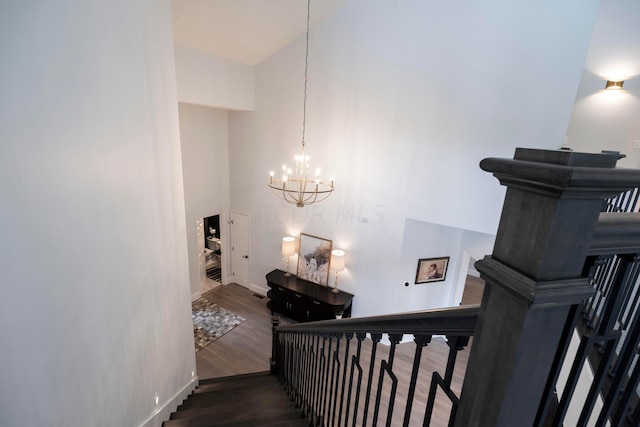 stairs featuring a notable chandelier and wood-type flooring