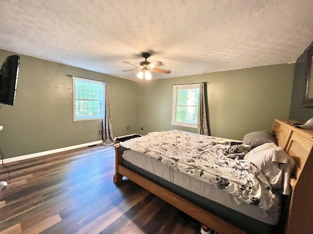 bedroom with ceiling fan, dark hardwood / wood-style flooring, and a textured ceiling